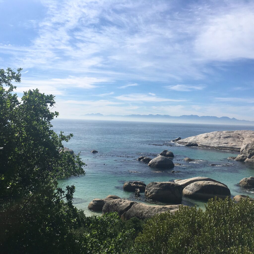 turquoise water at boulders with rocks and blue skies in perfect view