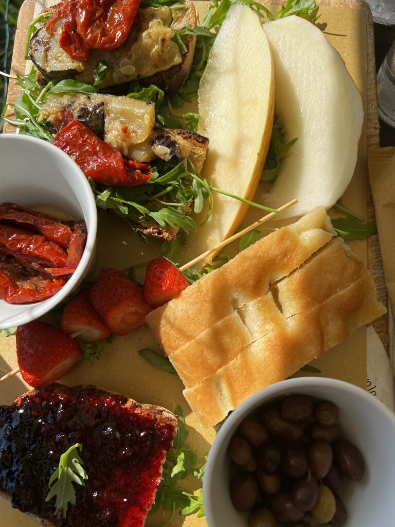 a platter with focaccia, fresh fruit and roasted vegetables 