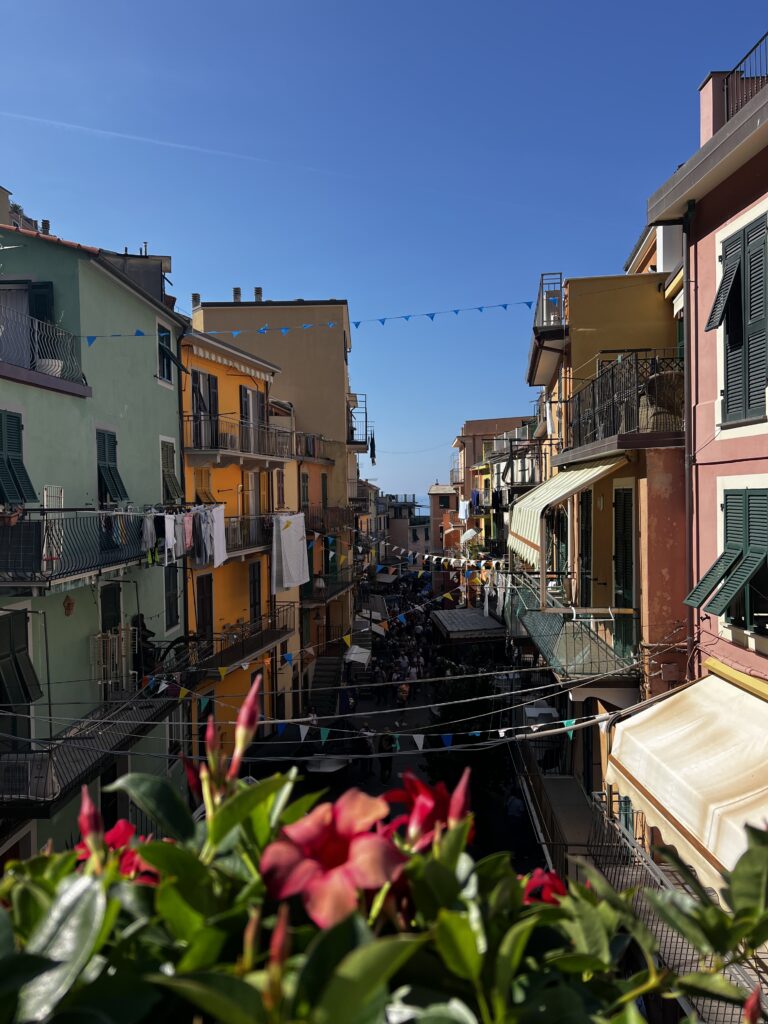 Manarola pathway from the station with the vibrant restaurants, bright colours and shops 