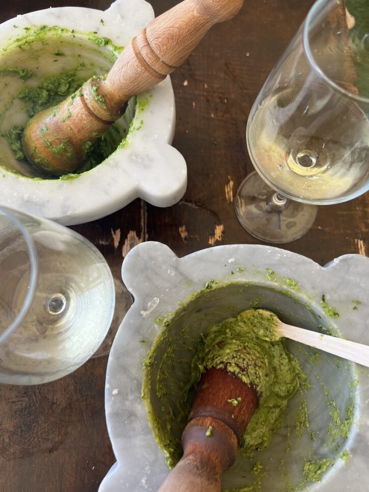 fresh pesto in pestle and mortar paired with white wine