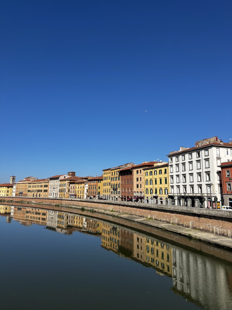 Houses in all shades of oranges along the Arno River in Pisa